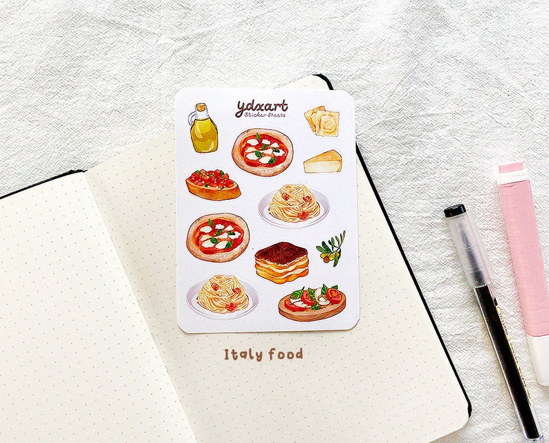 May include: A sheet of stickers featuring illustrations of Italian food, including pizza, pasta, tiramisu, and bruschetta. The stickers are on a white background with the text "yolxart sticker treats" and "Italy food".