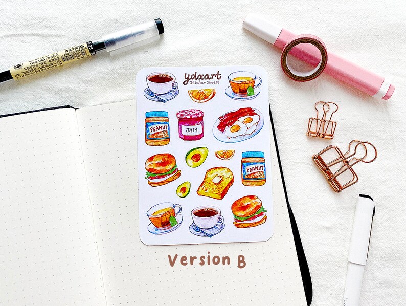 May include: A sheet of stickers featuring various breakfast foods, including a bagel sandwich, toast, eggs, bacon, peanut butter, jam, and coffee. The stickers are illustrated in a watercolor style and are perfect for adding a touch of whimsy to your planner or journal.