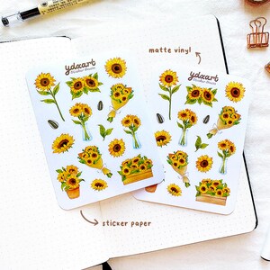 Peut inclure: Deux feuilles d'autocollants de tournesols, l'une sur du vinyle mat et l'autre sur du papier autocollant. Les autocollants pr&eacute;sentent diverses illustrations de tournesols, notamment des tournesols simples, des bouquets et des tournesols en pot. Le texte "ydxart Sticker Sheets" est imprim&eacute; sur les deux feuilles.