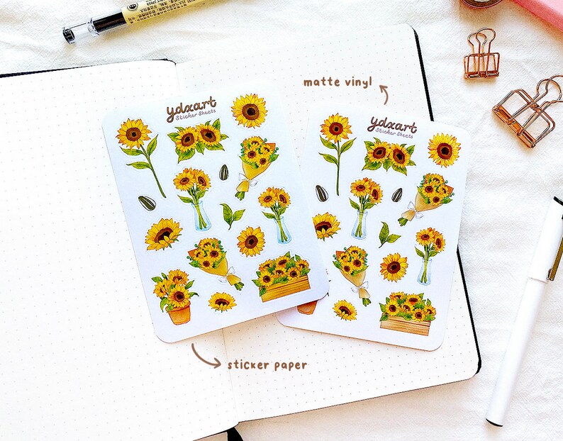 Peut inclure: Deux feuilles d'autocollants de tournesols, l'une sur du vinyle mat et l'autre sur du papier autocollant. Les autocollants pr&eacute;sentent diverses illustrations de tournesols, notamment des tournesols simples, des bouquets et des tournesols en pot. Le texte "ydxart Sticker Sheets" est imprim&eacute; sur les deux feuilles.