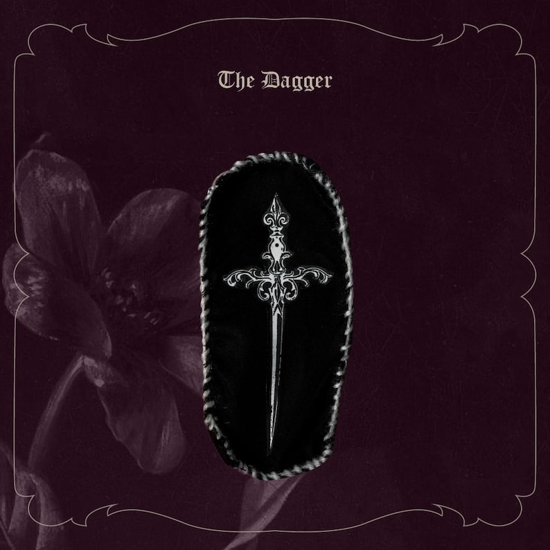 May include: An illustration of a dagger with intricate silver detailing on a black background. The text "The Dagger" is displayed at the top. The image has a gothic or fantasy theme, with a dark purple floral element.