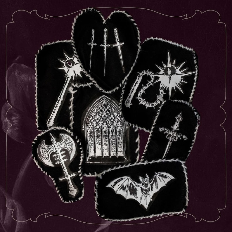 May include: A selection of black patches with white stitching, showcasing gothic and fantasy designs. The patches depict a mace, swords, a window, a bat, a sword, an axe, and a spiked whip.