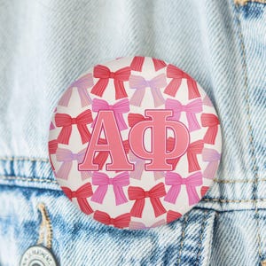 May include: A set of three ceramic mugs with a speckled, matte finish. The mugs are in shades of cream, light gray, and dark gray. Each mug has a simple, modern design and a rounded handle. The mugs are stacked on top of each other.