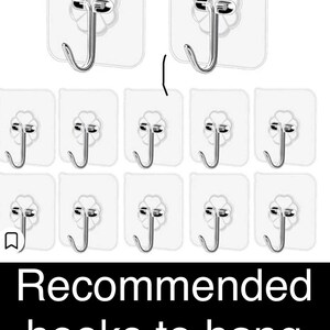 May include: Ten clear, adhesive hooks with a silver metal hook. The hooks are designed to be stuck to a wall or other surface. The hooks are arranged in three rows of three hooks each. The text "Recommended hooks to hang your hearts" is displayed below the hooks.