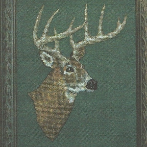 May include: A framed cross-stitch embroidery of a white-tailed deer buck with large antlers. The deer is facing right and has a brown and white coat. The background is a dark green.