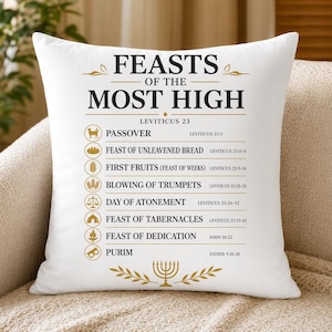以下が含まれることがあります： 白の装飾枕に、黒と金の文字で「FEASTS OF THE MOST HIGH」と書かれています。枕には、過越の祭り、種なしパンの祭り、プリムなど、宗教的な祝日が記載されています。下部には金のメノラーがあります。