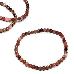A pink and brown beaded bracelet made of small round beads.