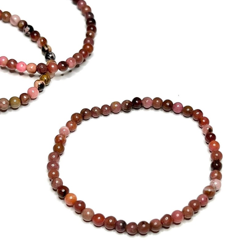 A pink and brown beaded bracelet made of small round beads.