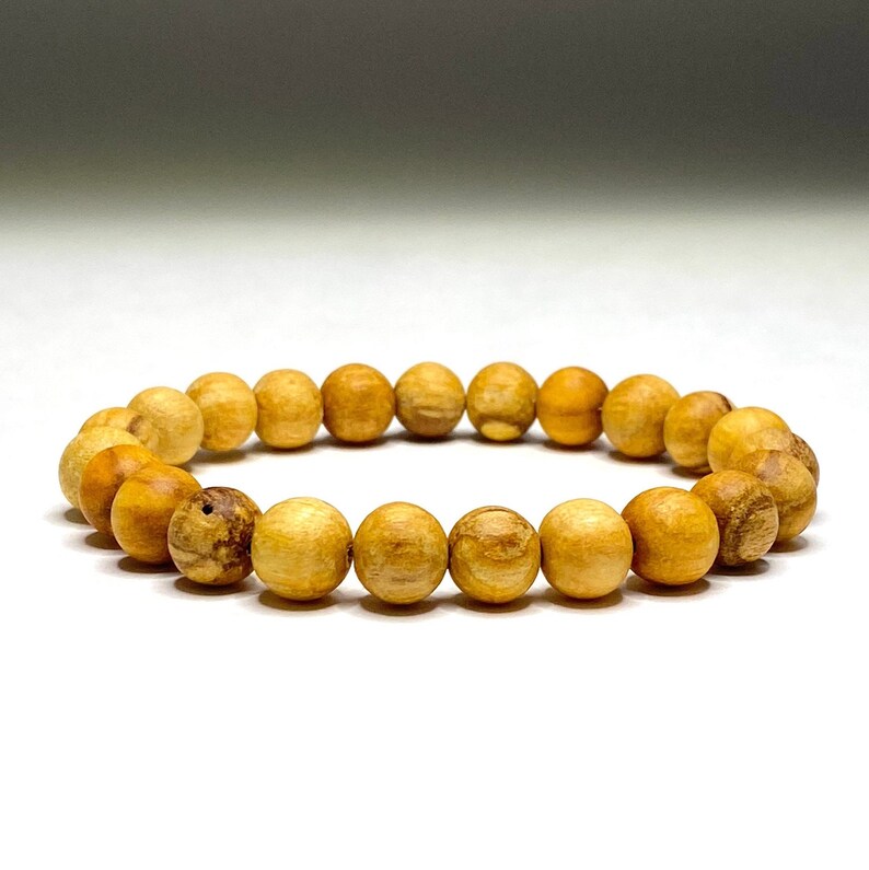 A wooden beaded bracelet with light brown beads. The bracelet is made of natural wood and has a simple design.