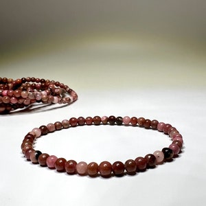 A pink and brown beaded bracelet made of small round beads.