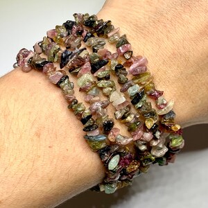 A multi-colored chip bracelet made of small, irregular shaped chips of watermelon tourmaline. The chips are in shades of green, pink, black, and brown.