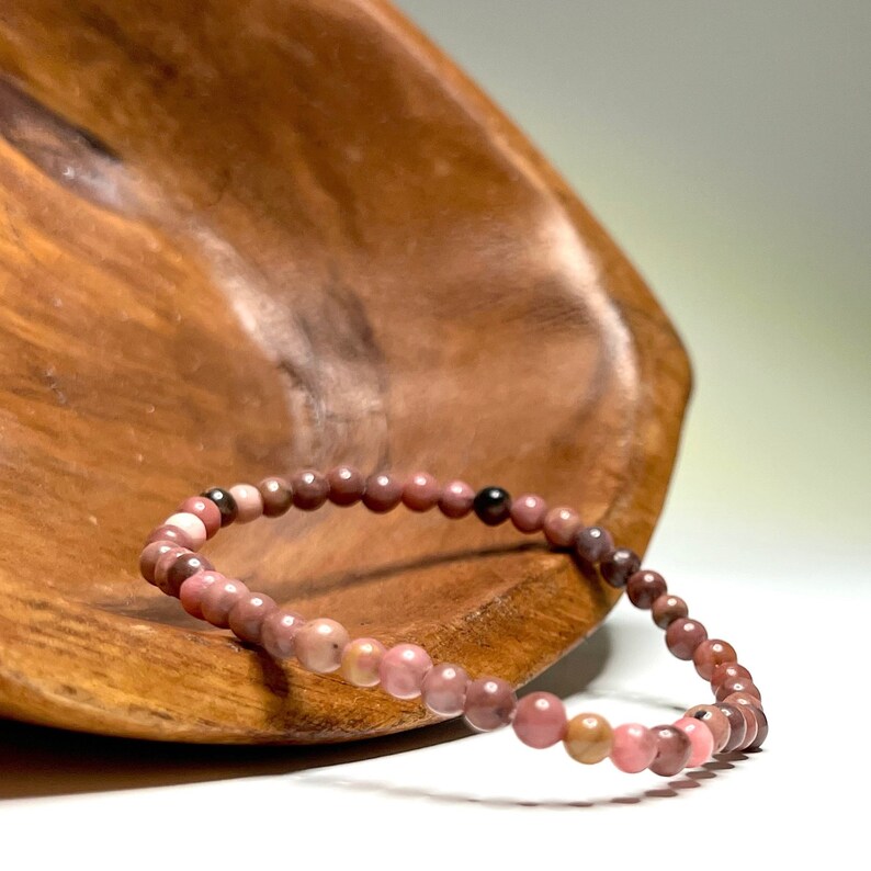 A pink and brown beaded bracelet on a wooden surface.