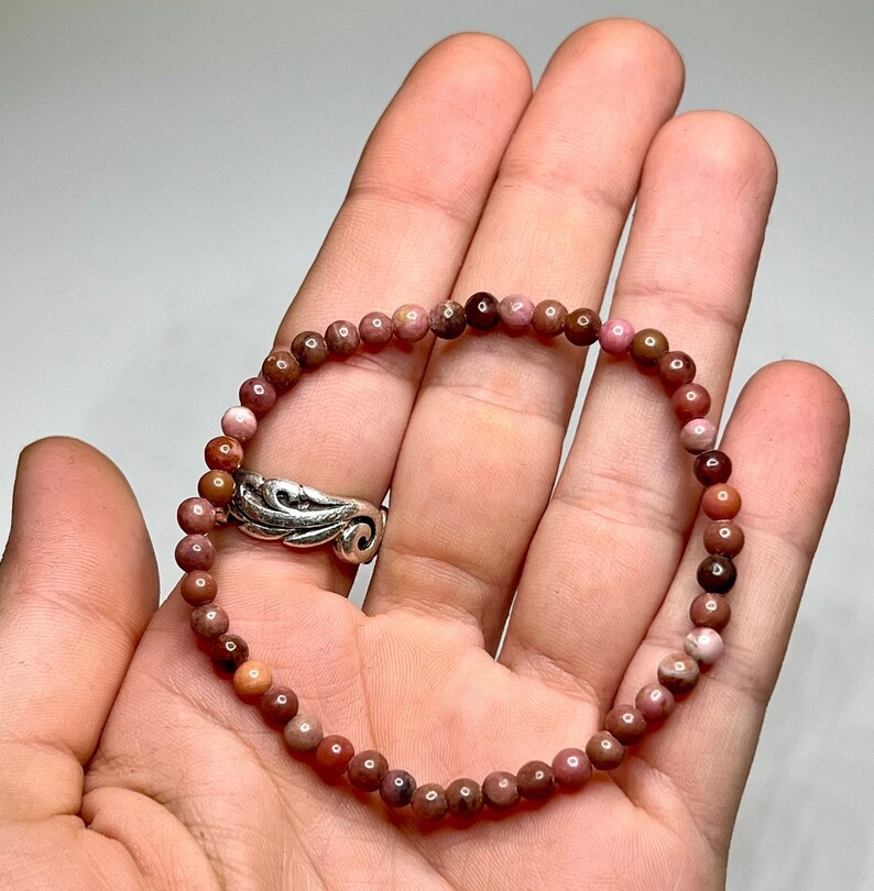 A pink and brown beaded bracelet made of small round stones.