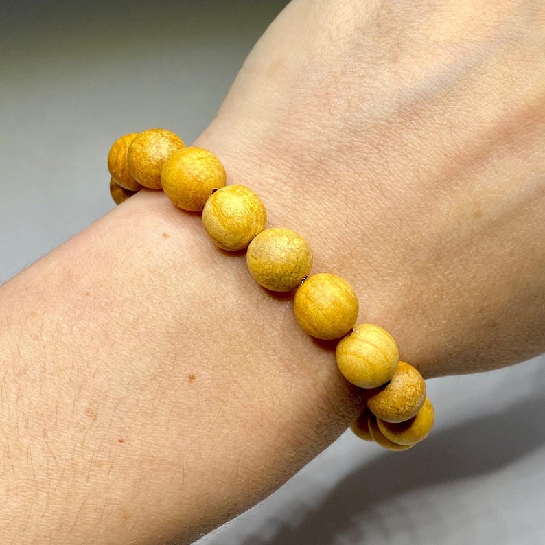 A bracelet made of round, yellow wood beads.