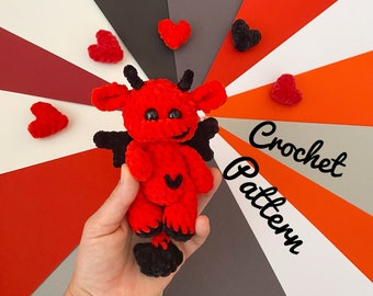 May include: Red crochet devil amigurumi toy with black horns and wings. The toy is sitting on a hand against a colorful background with the text "Crochet Pattern".