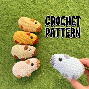 Op de afbeelding: Een verzameling handgemaakte gehaakte cavia's in verschillende kleuren, waaronder bruin, geel en lichtgrijs. De tekst "CROCHET PATTERN" staat in een vetgedrukte, zwarte letter. De cavia's hebben kleine zwarte ogen en bruine of grijze accenten.