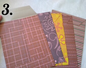 May include: A set of five decorative envelopes with different patterns. The envelopes are brown with pink and white accents. The envelopes are made of paper and have a flap on the top.