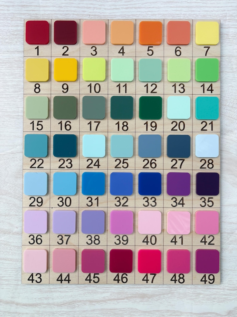 Puede incluir: Una carta de colores de madera con 49 muestras de colores numeradas. Las muestras est&aacute;n dispuestas en una cuadr&iacute;cula y muestran una variedad de colores, incluyendo rojos, naranjas, amarillos, verdes, azules, morados y rosas. Cada muestra es cuadrada.