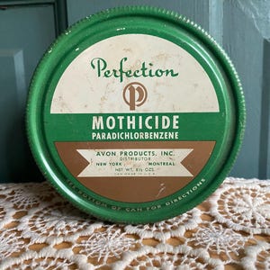 May include: Vintage green Perfection Mothicide can with white and brown text. The label reads "Mothicide Paradichlorbenzene" and "Avon Products, Inc." The can is round and has a ridged edge. Net weight is 8 1/2 oz.