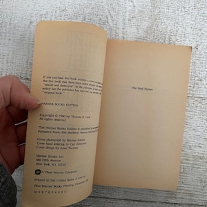 May include: A close-up of the copyright and publishing information for a Warner Books edition of a book. The text includes the copyright year, author, publisher, and printing information. The book is published by Putnam's Sons and printed in the United States of America.