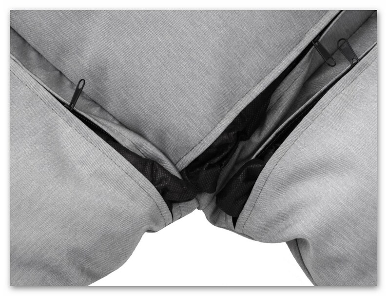 May include: Close-up of a grey zipped cushion cover with a black mesh lining. The zipper is open, revealing the lining.