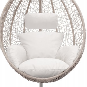 May include: A white wicker egg-shaped hanging chair with a white cushion and a white headrest. The chair is suspended from the ceiling by a metal chain.