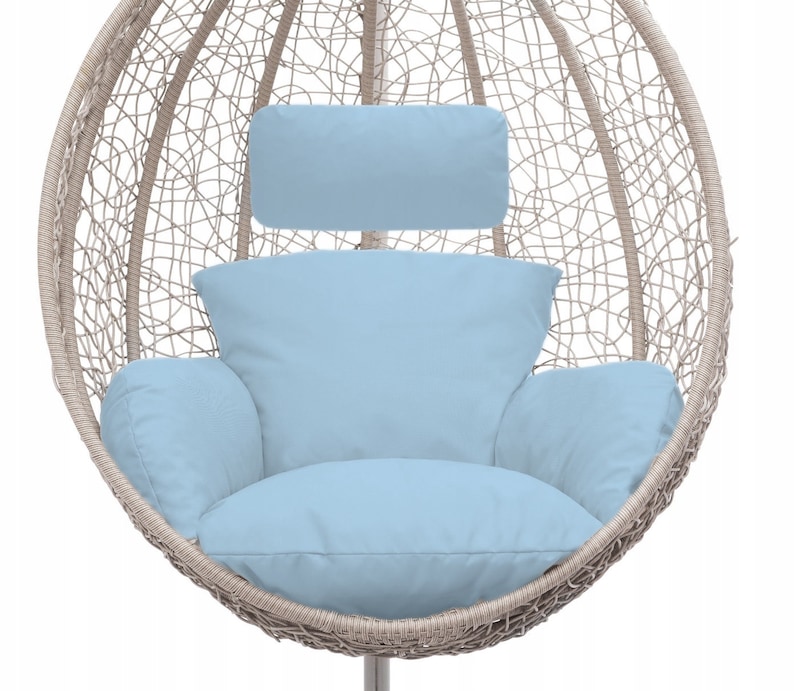 May include: A beige wicker egg-shaped hanging chair with a light blue cushion and a matching headrest.