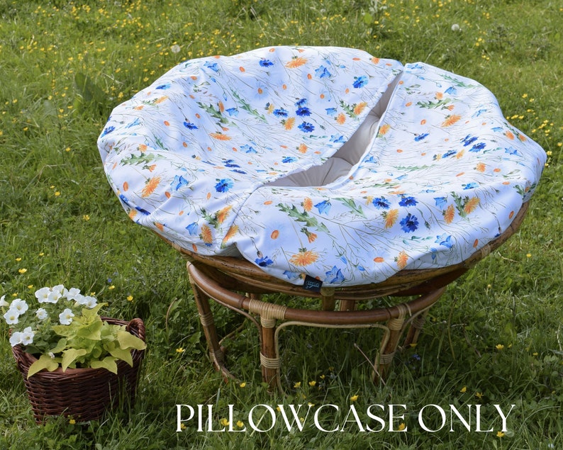 May include: A white and blue floral patterned chair cushion cover with a  "PILLOWCASE ONLY" text overlay. The cushion cover is on a round, wicker chair.