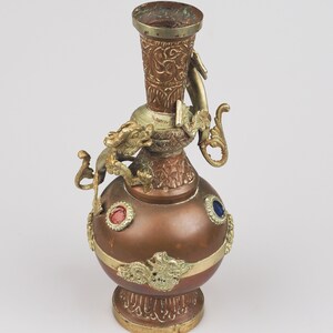 May include: A copper vase with a dragon design and three blue and red gemstones. The vase has a gold-coloured top and base.