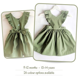 Girls pinafore dress in 26 colour options. Sage green sundress with flutter sleeves and statement bow. Matching baby & toddler sizes.