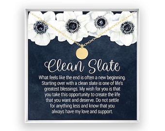 May include: A gold-toned necklace with a small circular pendant displayed on a card featuring white anemone flowers against a dark blue background. The card includes the text Clean Slate and a message about new beginnings and life opportunities.