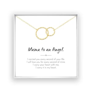 a necklace with two circular pendants, and there is a message written in black text below the necklace.