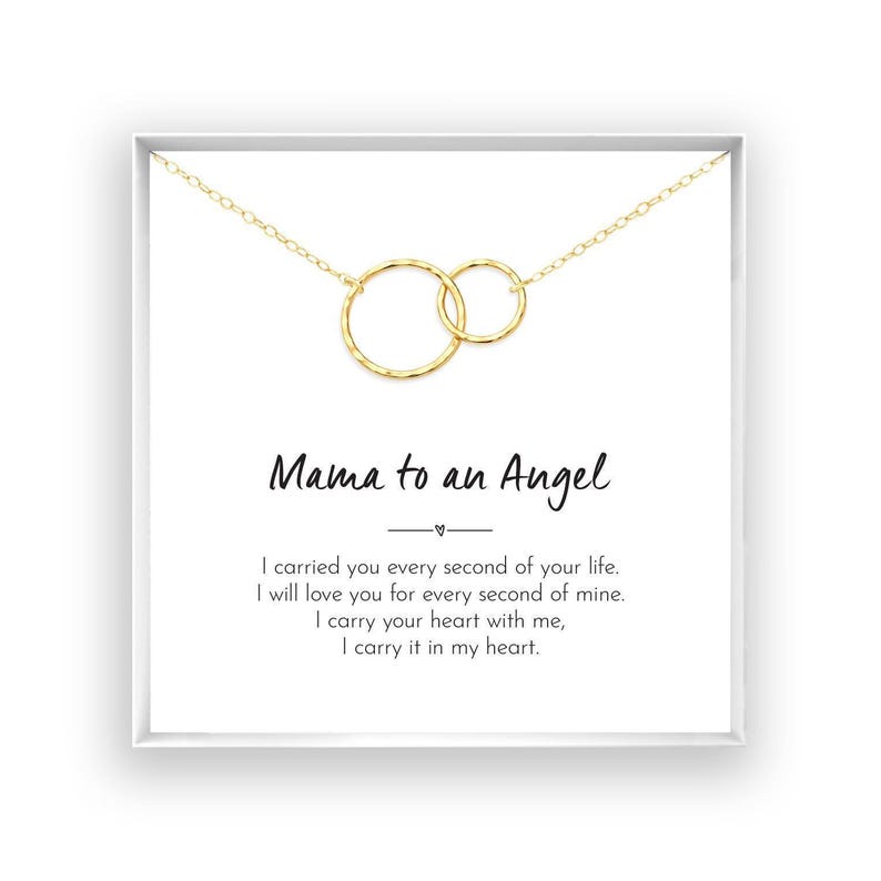 a necklace with two circular pendants, and there is a message written in black text below the necklace.