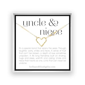 May include: A gold-toned necklace featuring a delicate heart-shaped pendant and a single small clear stone on a thin chain. The necklace is displayed on a white card with the text "uncle & niece" and a poem about their special bond.
