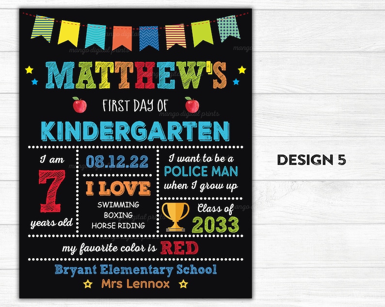 Puede incluir: Un cartel negro de pizarra con decoraciones y texto coloridos. Dice "Matthew's First Day of Kindergarten" e incluye detalles como la edad, las actividades favoritas y las aspiraciones futuras. El cartel est&aacute; decorado con banderas coloridas, estrellas y una manzana roja.