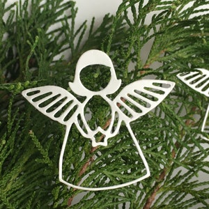 Pode incluir: Adorno de anjo branco recortado com asas e halo. O adorno &eacute; feito de metal e tem um design delicado. &Eacute; perfeito para adicionar um toque de eleg&acirc;ncia &agrave; sua &aacute;rvore de Natal.
