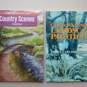 May include: Two instructional art books placed side by side. The left book is titled Paint This with Jerry Yarnell Country Scenes in Acrylic, featuring a landscape painting of a wooden bridge over a stream. The right book is titled Carlson's Guide to Landscape Painting by John F. Carlson, showing a snowy forest scene.