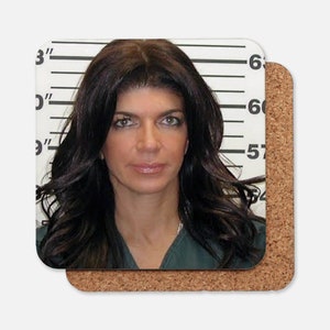 May include: A mugshot of a woman with long dark hair. She is wearing a green jumpsuit and is standing in front of a white wall with black lines. The numbers 6'0" and 5'7" are visible on the wall.