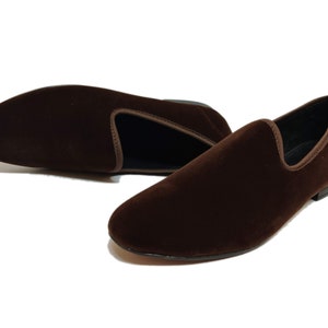 May include: A pair of brown velvet loafers. The loafers have a pointed toe and a slip-on design.