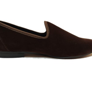 May include: A pair of brown velvet loafers with a pointed toe and a black rubber sole.