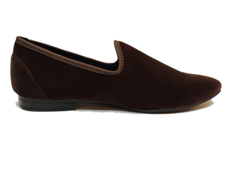 May include: A pair of brown velvet loafers with a pointed toe and a black rubber sole.