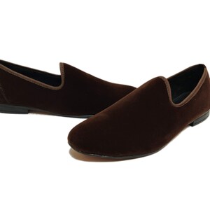 May include: A pair of brown velvet loafers with a pointed toe and a slip-on design.