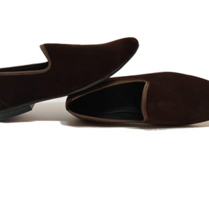 May include: A pair of brown velvet loafers with a pointed toe and a slip-on design.