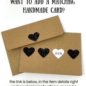 May include: A brown envelope with a black heart sticker and the text "WANT TO ADD A MATCHING HANDMADE CARD?"  The envelope is sitting on a white surface.  The text "10.6.18" is on a white circle sticker.