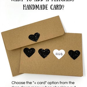 Może przedstawiać: Dwie brązowe koperty z czarnymi sercami z brokatem i białym sercem z tekstem "10.6.18". Tekst "WANT TO ADD A MATCHING HANDMADE CARD?" znajduje się w g&oacute;rnej części obrazu. Tekst "Choose the "+ card" option from the drop down menu when checking out" znajduje się w dolnej części obrazu.