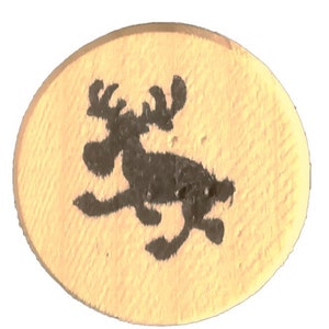 Puede incluir: Un token redondo de madera con una silueta negra de un alce corriendo hacia la derecha.