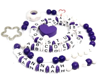 Könnte beinhalten: Eine violette und weiße Alphabet-Perlenkette mit einem sternförmigen Schlüsselanhänger und einem violetten Herz-Anhänger. Die Kette buchstabiert den Namen "HANNAH".