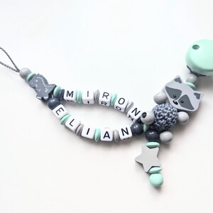 Schnullerkette Doppelname Waschbär mit Dino