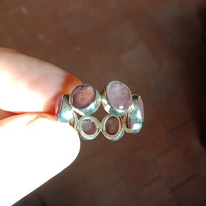 Peut inclure: Une bague en argent avec plusieurs pierres précieuses rondes roses serties dans la bande.