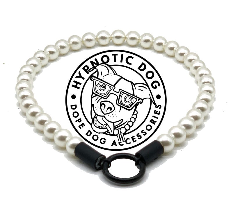 May include: A white pearl beaded collar featuring a black circular metal ring at the center. The collar is displayed in front of a circular logo with the text HYPNOTIC DOG DOPE DOG ACCESSORIES and an illustration of a dog wearing spiral glasses.